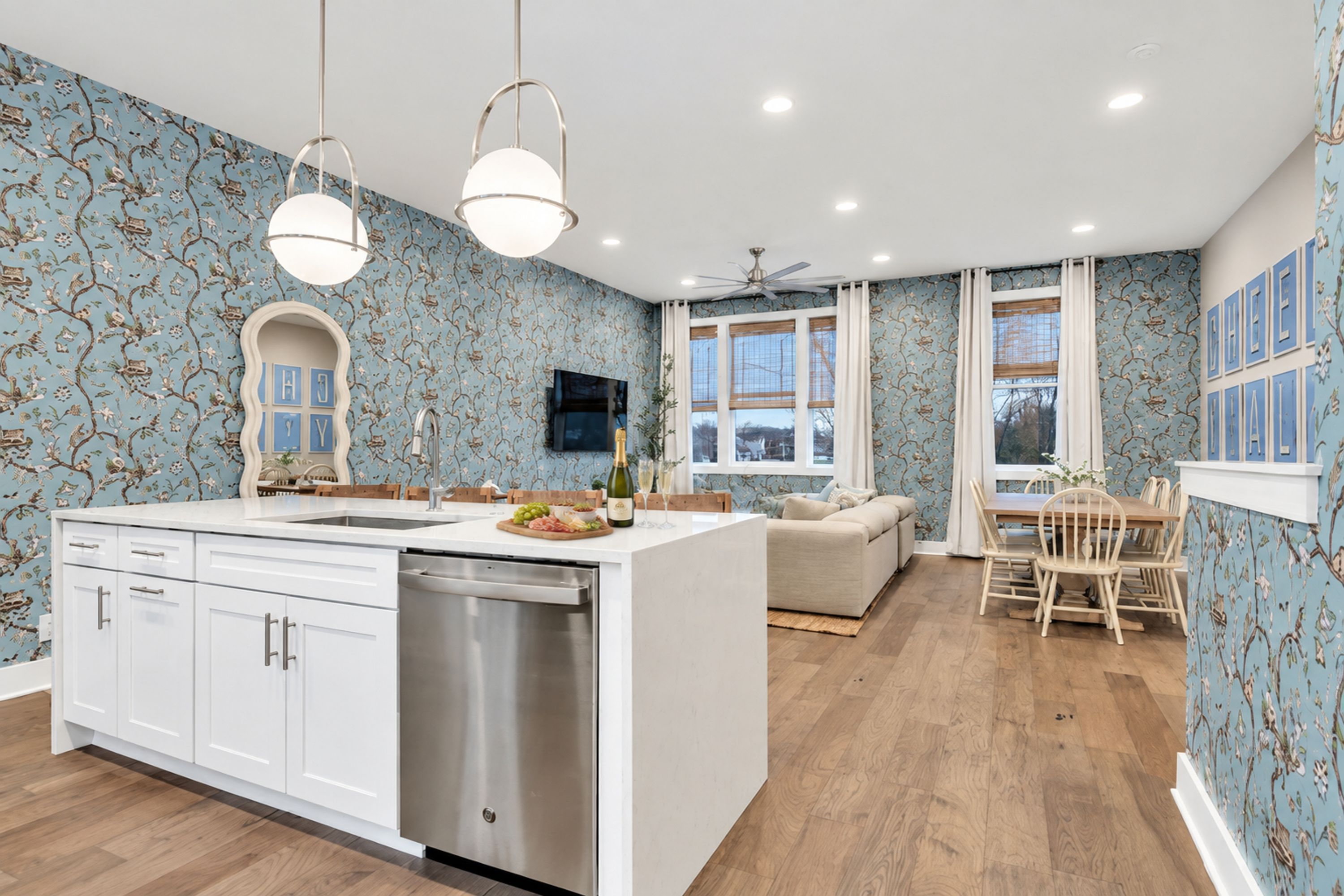 A modern kitchen with a central island, white cabinetry, and a dishwasher.