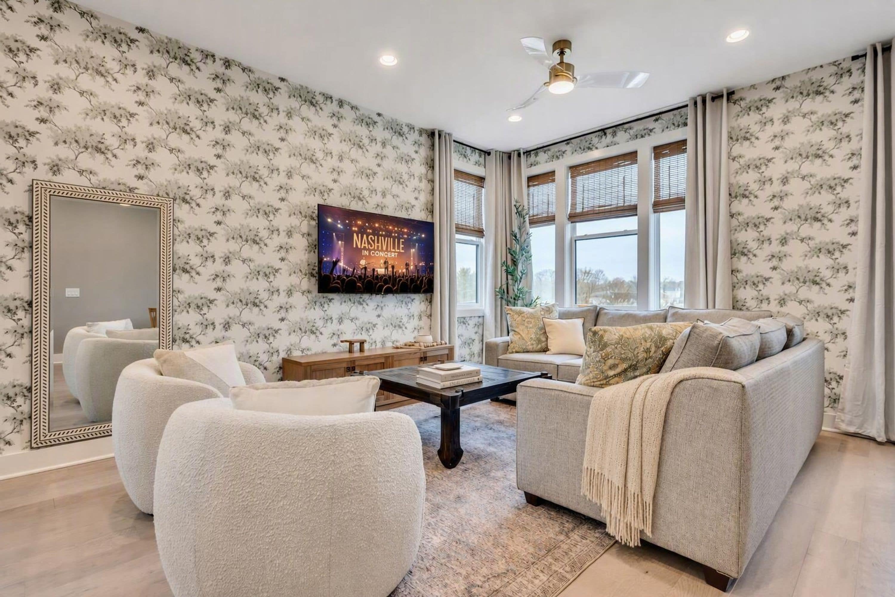 A living room with a large mirror, a flat-screen TV, a sofa, and a coffee table.
