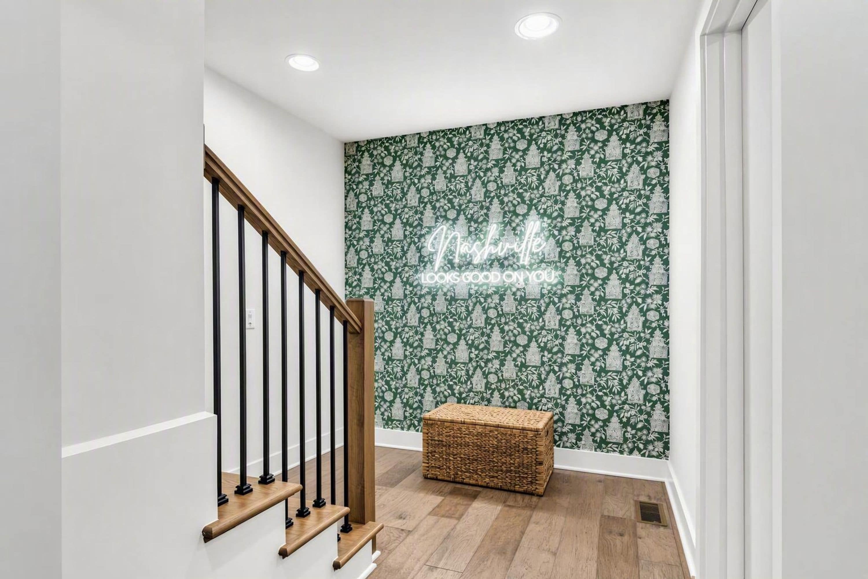 A staircase with wooden handrails and a woven basket at the bottom.