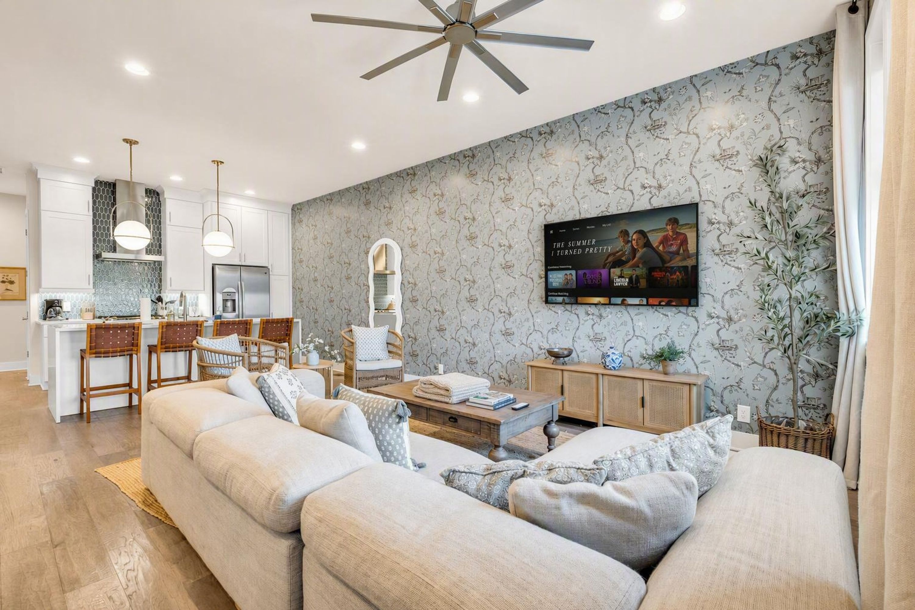 A modern living room with a sofa, a coffee table, and a television mounted on the wall.