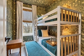 A bunk bed room with a window, a bedside table, and a lamp. - 2 Homes - Rooftop Decks - Fire Pit - Sleeps 24 (Nashville)