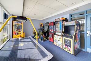 A room with a pool table, arcade games, and a basketball hoop. - 12 Floors Up With King Bunks and Resort Pool (Orlando)