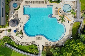 A large swimming pool with a unique shape, surrounded by sun loungers and a small circular pool. - 12 Floors Up With King Bunks and Resort Pool (Orlando)