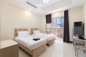 A hotel room with two beds, a desk, a chair, and a television. - Stayshort - Spacious 11-bedroom Villa Stay at Casa Royale JVC (Dubai)