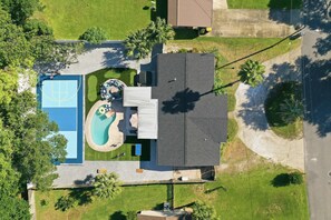 A residential property with a swimming pool, a tennis court, and a covered patio area. - FWB Paradise Sports Court Hot Tub Putt Putt (Fort Walton Beach)