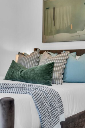 A bed with a patterned throw, multiple pillows, and a headboard. - Nashville Hideaway Private Rooftop City View (Nashville)