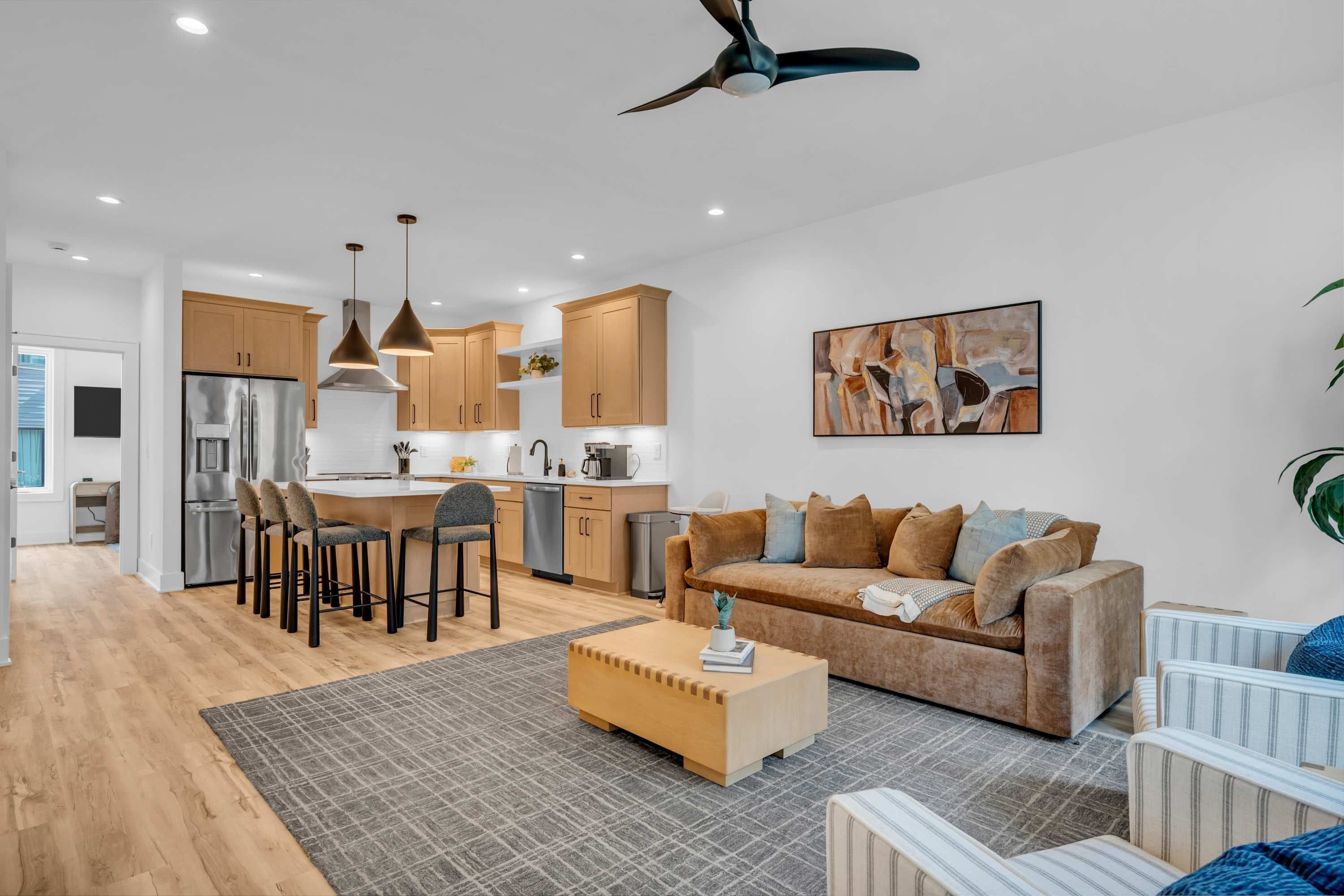 A modern living space with a kitchen, dining area, and seating area.