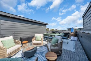 A rooftop patio with outdoor furniture, a fire pit, and a view of the city skyline. - Nashville Hideaway Private Rooftop City View (Nashville)