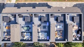 A rooftop terrace with multiple seating areas, a pool, and a dining setup.