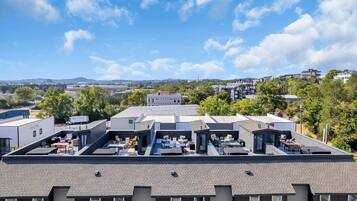 A residential building with multiple roof terraces, each equipped with outdoor seating and tables.