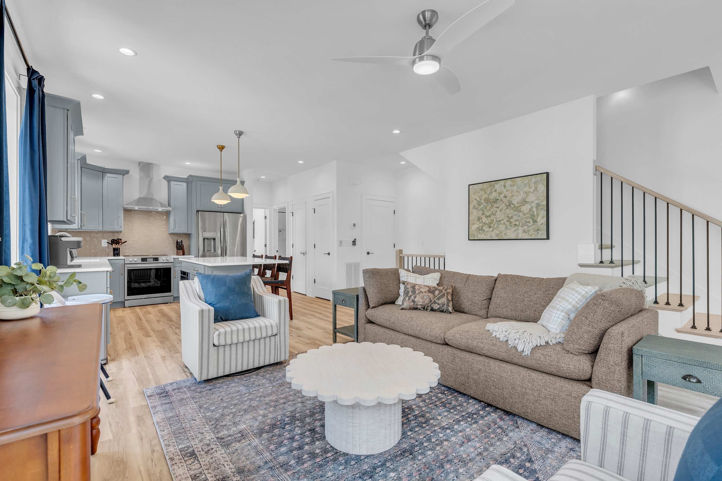 A modern living room with a sofa, a coffee table, and a dining area with chairs.