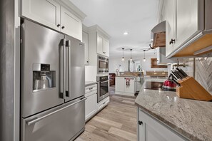 A modern kitchen with stainless steel appliances, a granite countertop, and wooden cabinetry. - Lake Norman Haven Private Dock Lake Views (Denver)