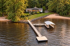 A lakeside property with a dock extending into the water, a covered boat ramp, and a house surrounded by trees. - Lake Norman Haven Private Dock Lake Views (Denver)