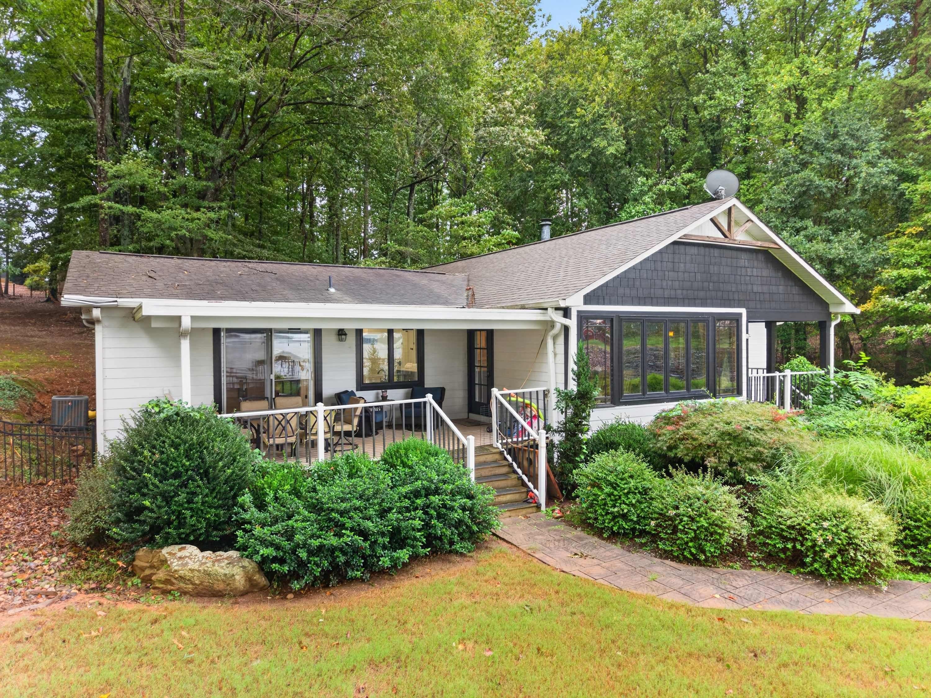 A single-story house with a covered porch, a satellite dish, and a well-maintained garden.