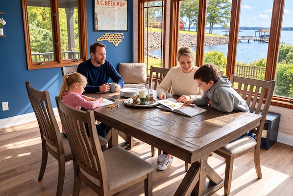 A family dining at a wooden table with a view of a lake and dock. - Lake Norman Haven Private Dock Lake Views (Denver)