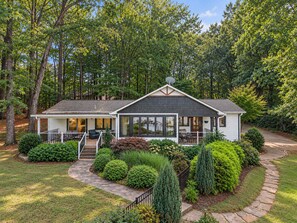 A two-story house with a covered porch, a satellite dish, and a well-maintained garden with various shrubs and a stone pathway. - Lake Norman Haven Private Dock Lake Views (Denver)