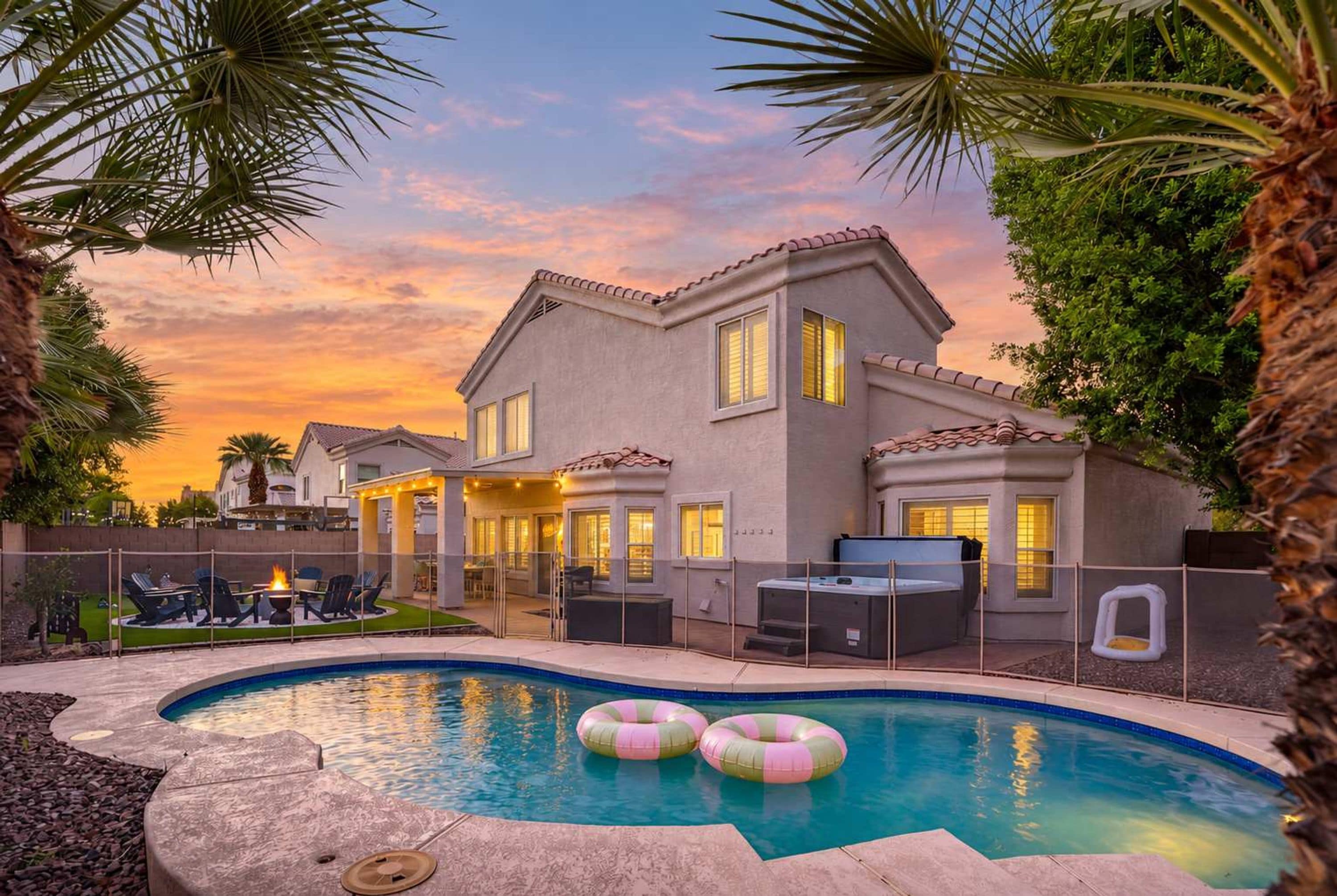 A residential property with a swimming pool, outdoor seating, and a patio area.