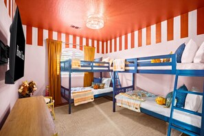 A bunk bed room with striped walls, a ceiling fan, and a television. - Adobe Afterglow Swim Soak Play Stay Awhile (Mesa)