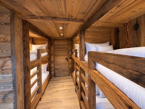 A narrow wooden corridor with bunk beds on either side, leading to a door at the end. - Chalet 'Le Manoir Valloire Ski' (Valloire)