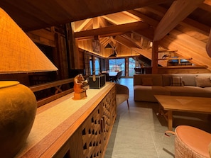 A cozy wooden interior with a sofa, a table, and a decorative sculpture. - Chalet 'Le Manoir Valloire Ski' (Valloire)