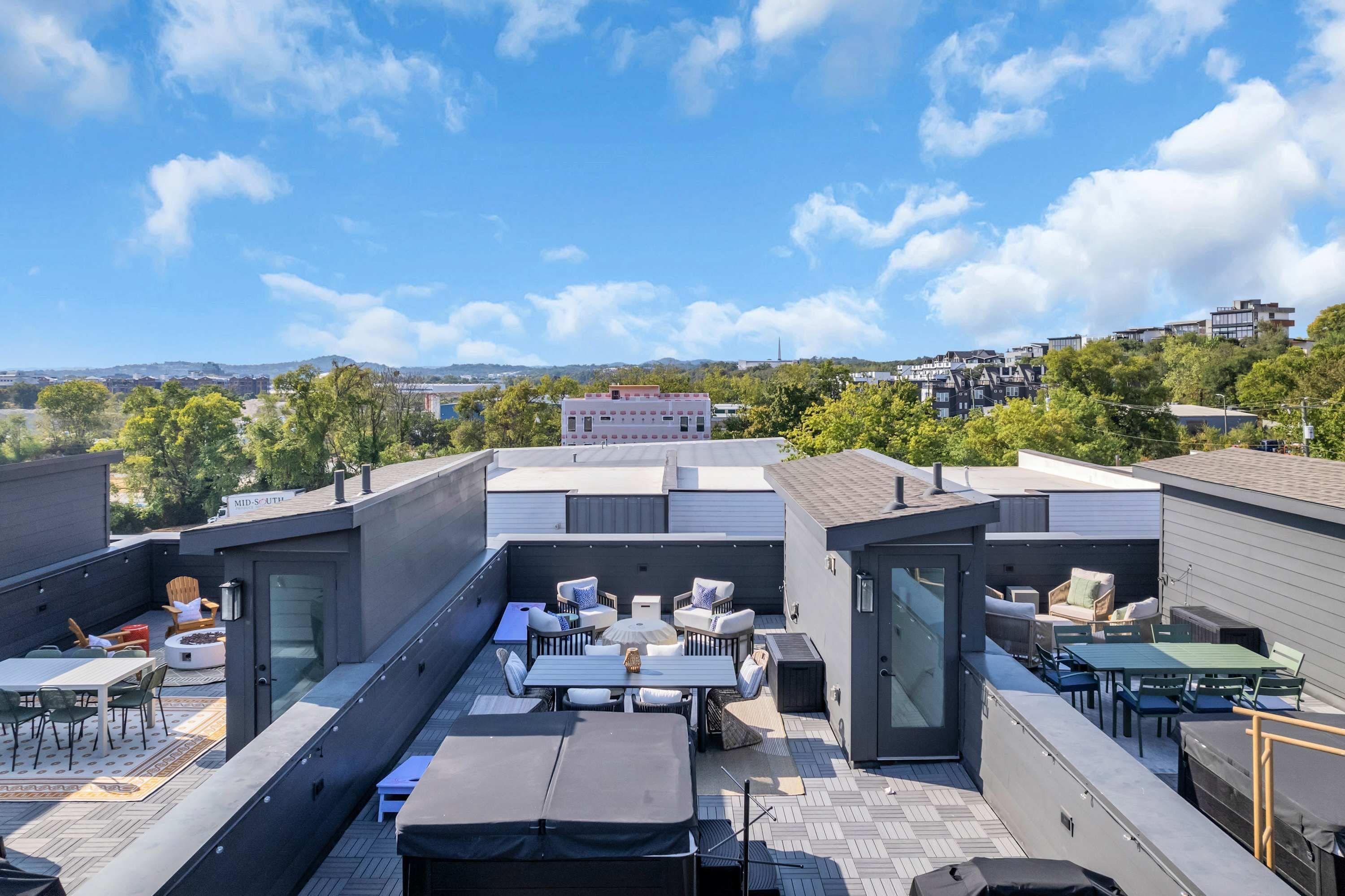 A rooftop patio with outdoor seating and a view of the cityscape.