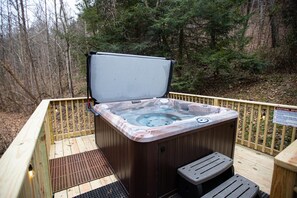Ein Whirlpool auf einer Holzterrasse mit einem Sicherheitsschild.