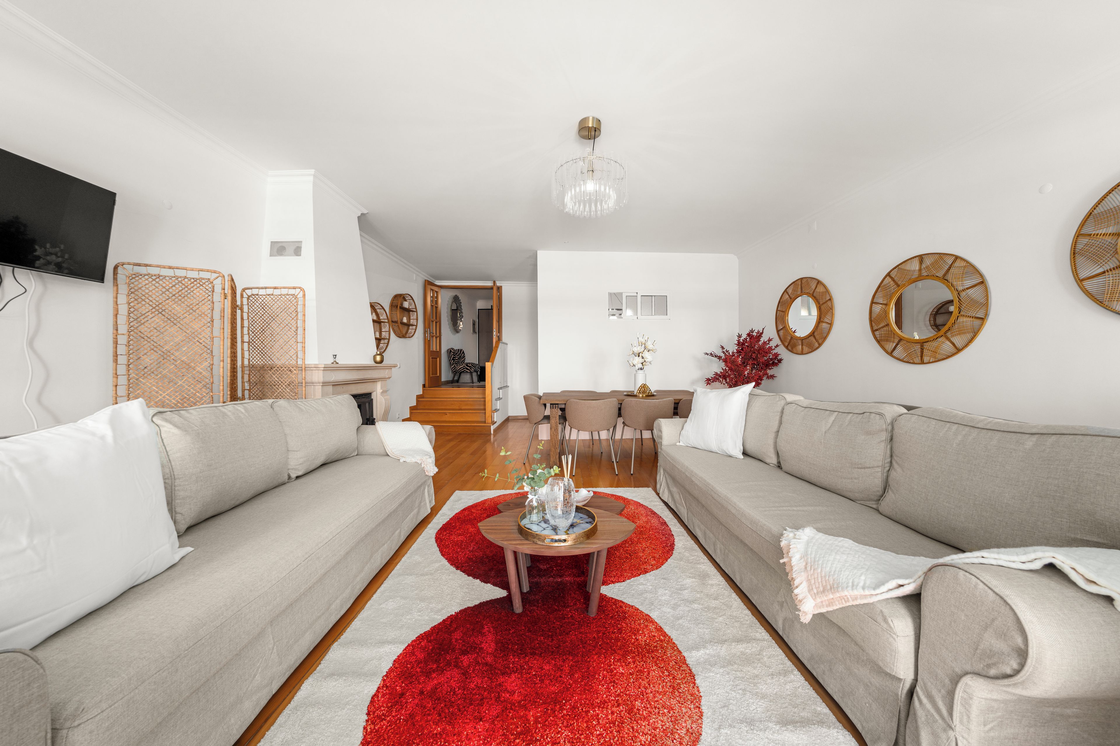 Un salon moderne avec deux canapés, une table basse et un tapis rouge.