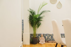 A room with a potted plant, a statue, and a chair. - Heart of Lisbon | Comfortable Stay for 10 w/AC (Lisbon)
