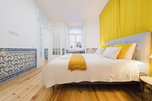 A hotel room with a large bed, a window with curtains, and a view of the street. - Heart of Lisbon | Comfortable Stay for 10 w/AC (Lisbon)