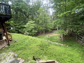 A backyard with a wooden deck, a stone pathway, and a wooden fence. - 5br Family Escape, Hot Tub, Game Room, Sleeps 12 (McGaheysville)