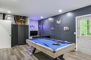 A pool table with pool cues and balls, a neon game controller sign, and a door with a window. - 5br Family Escape, Hot Tub, Game Room, Sleeps 12 (McGaheysville)