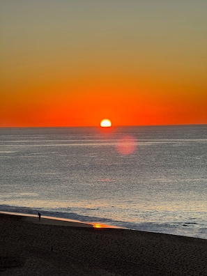 A sunset over a beach with a person walking along the shore. - Oceanfront 3BR Villa at Casa del Mar, Resort Amenities & Pickleball (San José del Cabo)