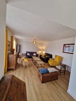 A living room with a sofa, chairs, a coffee table, a wooden cabinet, and a lamp. - Large, quiet house near Nantes (Vertou)