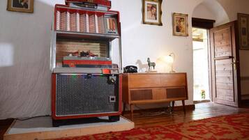 Ein Vintage-AMI-Jukebox in einem Raum mit Holzmöbeln, gerahmten Bildern an der Wand und einem gemusterten Teppich.