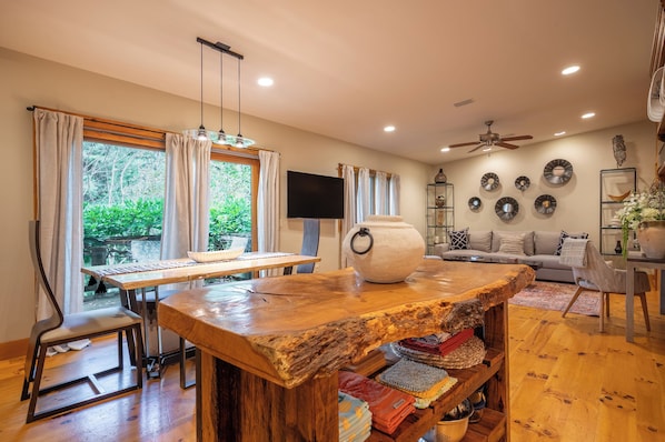 Una sala moderna con una mesa de centro de madera, un sofá y una televisión.