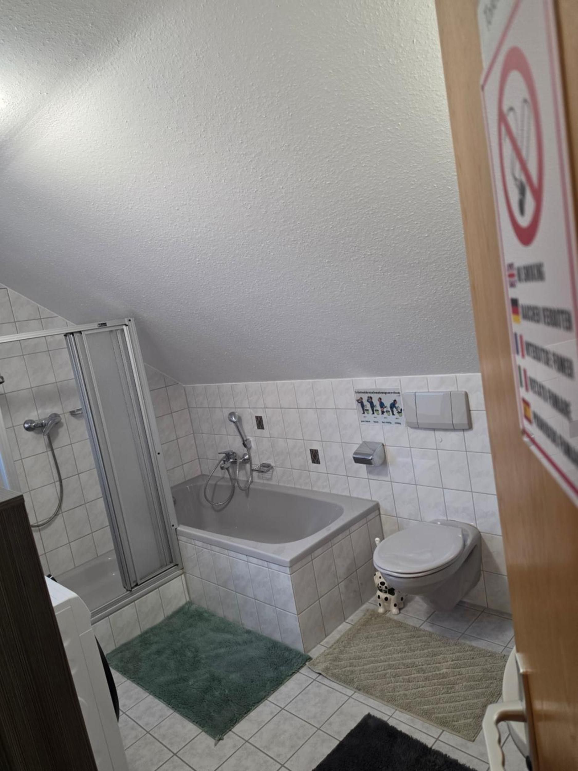 Ein Badezimmer mit Dusche, Badewanne, Toilette und einem Händetrockner.