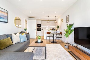 Ein modernes Wohnzimmer mit einer Couch, einem Couchtisch und einem Fernseher.