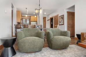 A modern living room with two green armchairs, a black coffee table, and a patterned rug. - Slopeside | Washer/Dryer | Hot Tub & Pool | On Bus Route (Steamboat Springs)