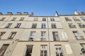 A multi-story building with a uniform facade, multiple windows, and balconies. - Charming Studio - Center of Paris Montorgueil (Paris)