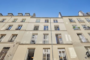 A multi-story building with a uniform facade, multiple windows, and balconies. - Charming apartment - Center of Paris Montorgueil (Paris)