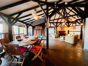 A wooden dining area with a table set for four, surrounded by chairs. - Sea-view villa in Tartane, sleeps 8 & spa (La Trinité)