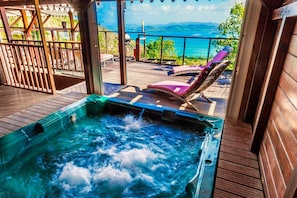 A hot tub on a wooden deck with a view of the sea. - Sea-view villa in Tartane, sleeps 8 & spa (La Trinité)