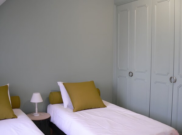 A hotel room with two beds, a bedside table with a lamp, and a wardrobe. - Country house 'Gîte Clos Saint Vincent' with Wi-Fi (Verdigny)
