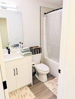 A modern bathroom with a toilet, sink, and shower area.