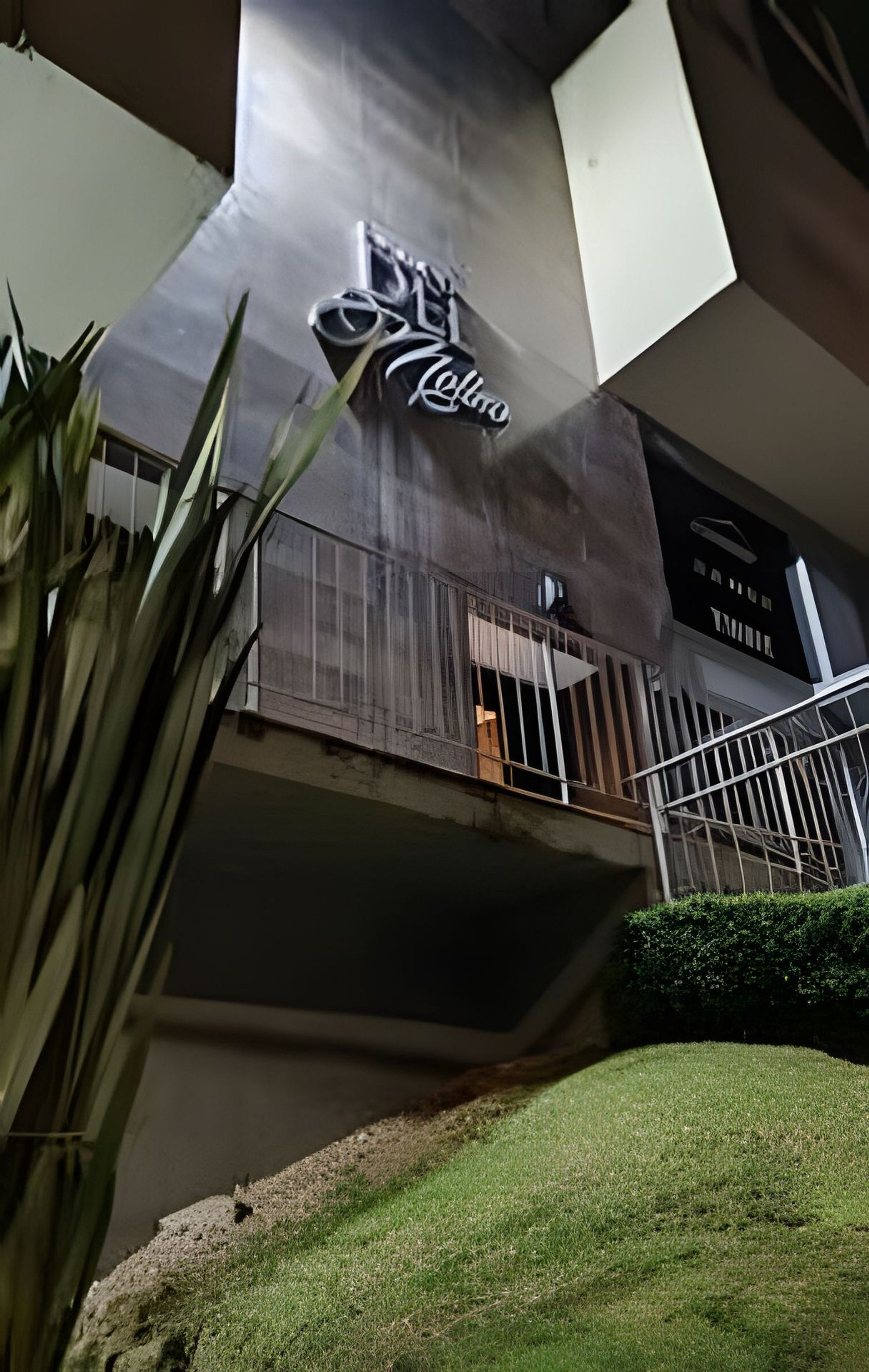 A building with a large sign reading 'Cielo' and a balcony with a metal railing.