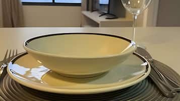 A table set with a bowl, a wine glass, and cutlery on a textured placemat.