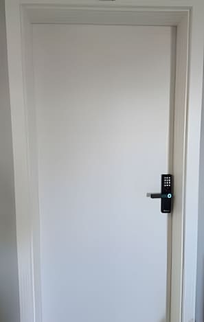 A white door with a modern electronic lock.