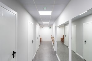 A corridor with white doors, a grey floor, and a ceiling with recessed lighting. - MalagaSuite Urban Beach B (Torremolinos)