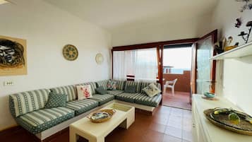 Un salon comprenant un canapé, une table basse et un coin repas avec une table et des chaises.