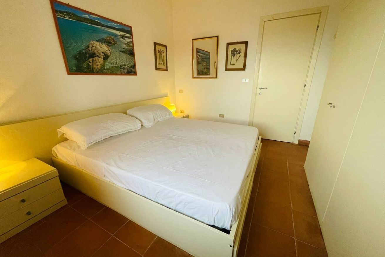 Une chambre à coucher avec un lit, des tables de chevet et une porte.